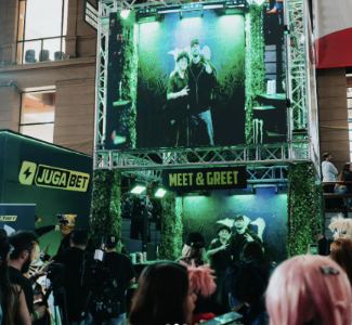 Lámina 2 de 3: Estructura del Meet & Greet de Monster, con pantalla gigante y JugaBet al lado